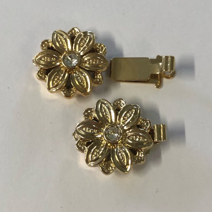 Schließe in Blumen Design                                                 1-reihige Schließe in Form einer Blume mit einem Kristal besetzt in der Mitte